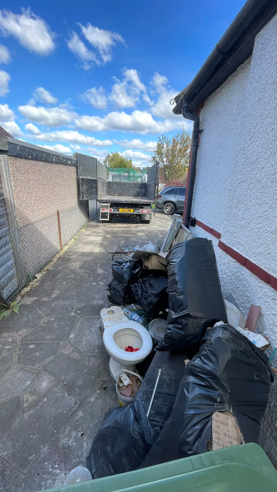 Bulky waste and old furniture piled outside a property before removal