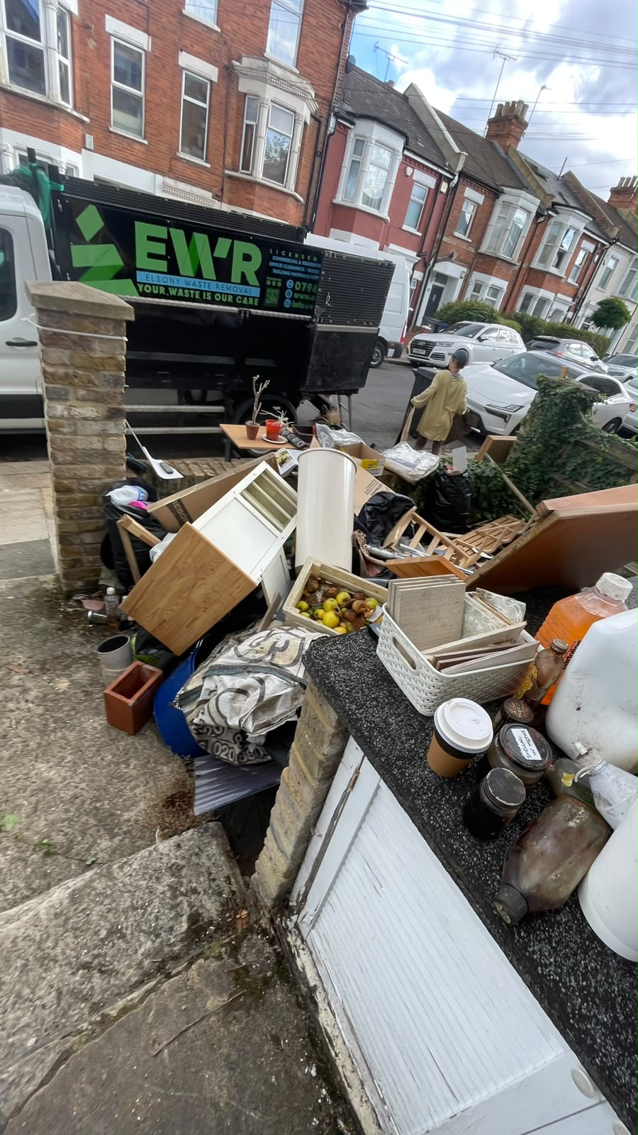 Construction debris piled in a front driveway before clearance