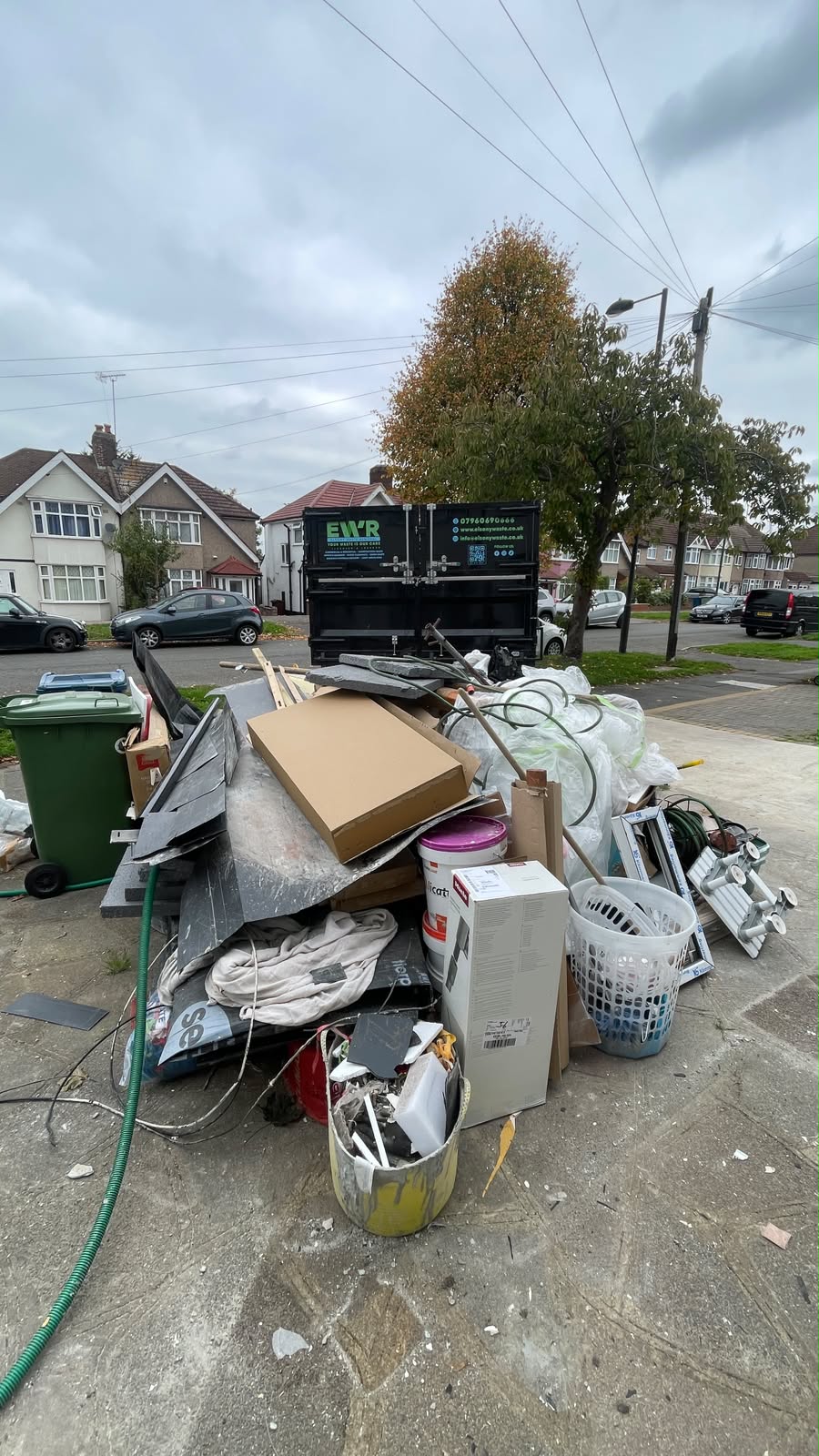 Pile of rubbish bags and boxes on a residential street awaiting collection