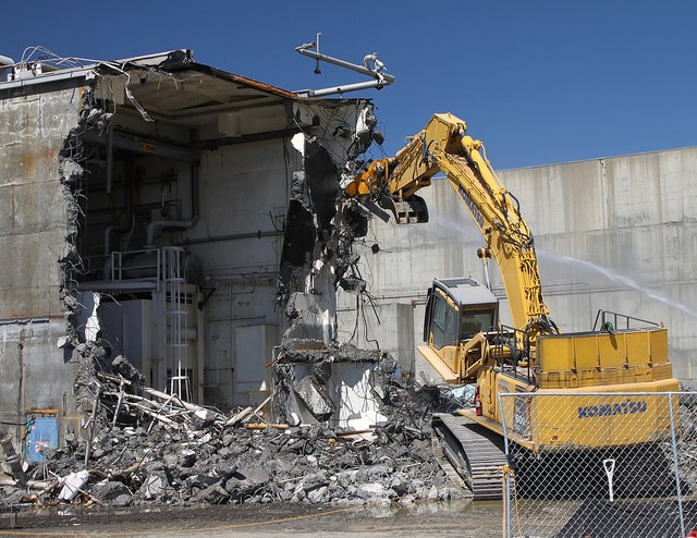 Excavator demolishing a concrete building structure