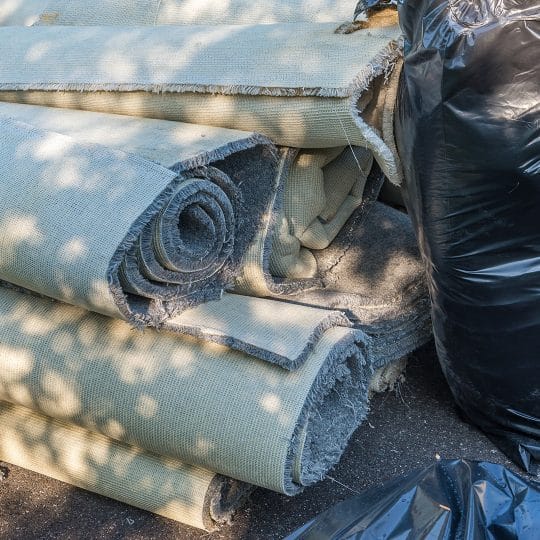 Rolls of old carpets removed from a construction project