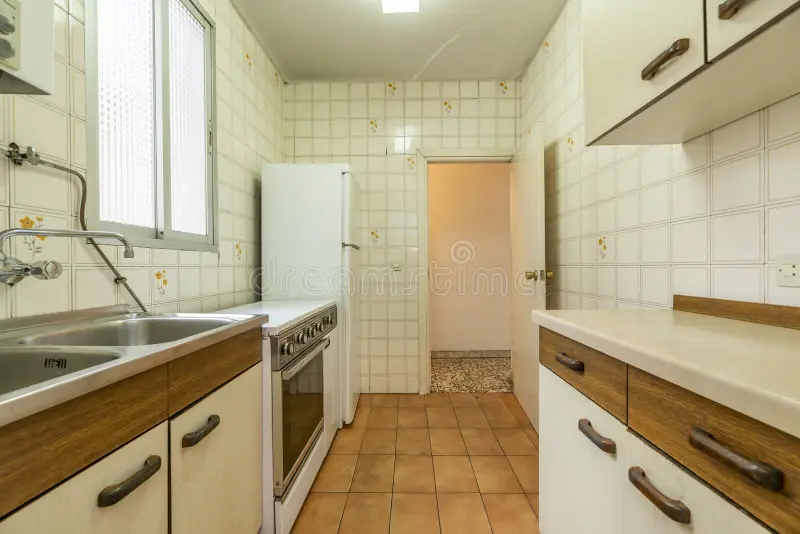 Old kitchen interior with tiles and cabinets being dismantled