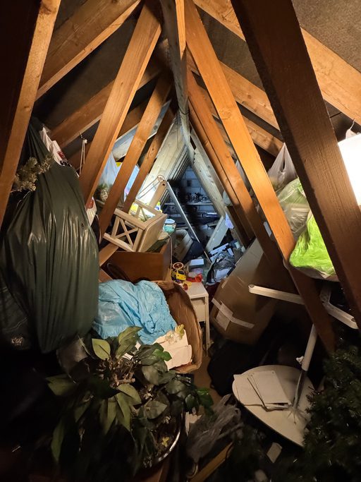 Cluttered attic space with stored household items