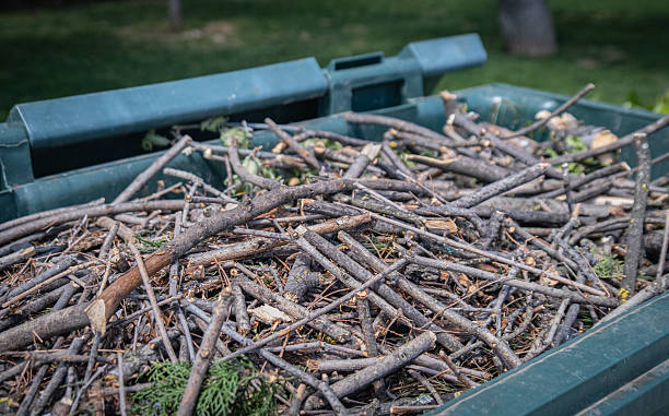 Green bin filled with small twigs and woody garden waste