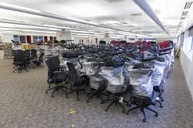 Room filled with stacked office chairs and desks