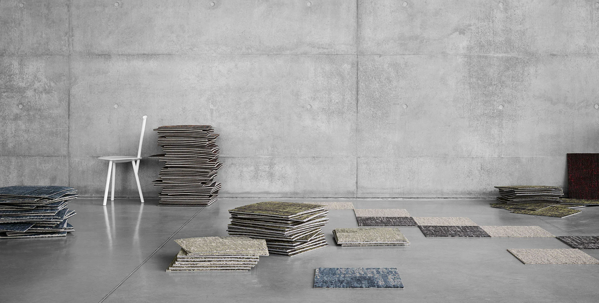 Stacks of carpet tiles on a concrete floor