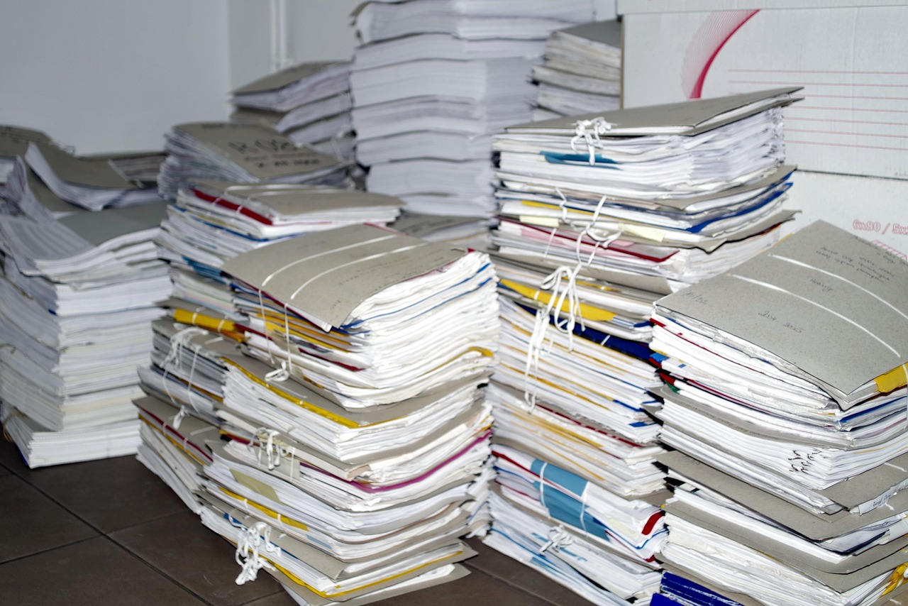 Stacks of printed office documents and paper