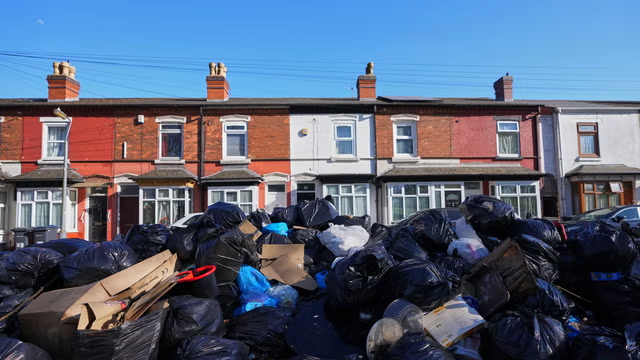 Pile of household rubbish bags and cardboard outside residential properties